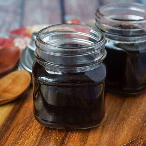 Homemade teriyaki sauce in two glass jars on a wooden surface