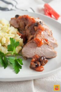pork tenderloin with rhubarb chutney on a white plate with mashed potatoes