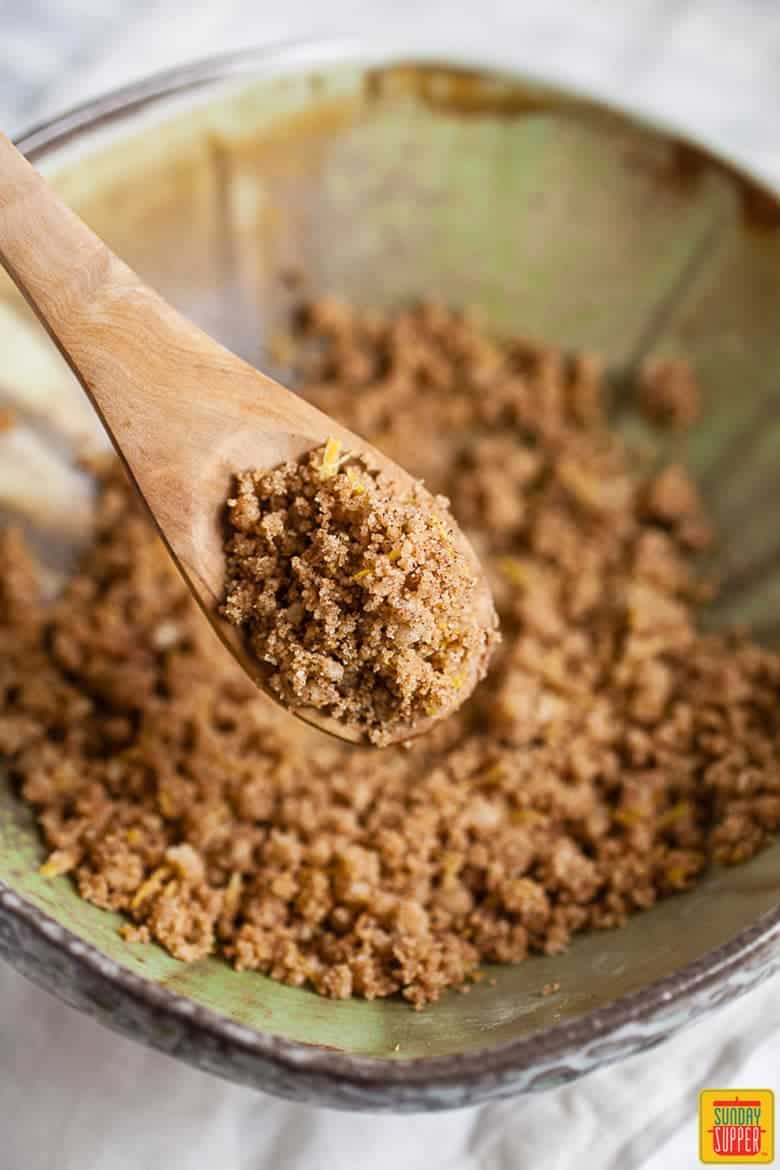 Cinnamon streusel topping with a wooden spoon in a bowl