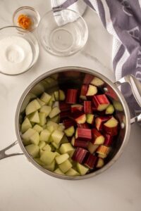 A saucepan filled half with chopped apple and half with chopped rhubarb