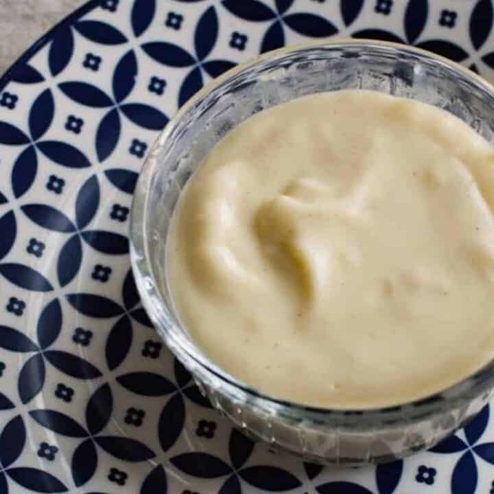 how to make cheese sauce - cheese sauce in a glass bowl on a blue plate