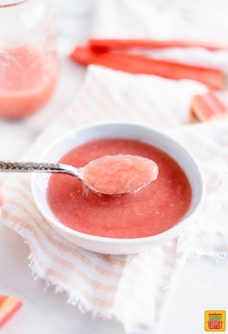 A spoonful of rhubarb sauce in a white bowl 