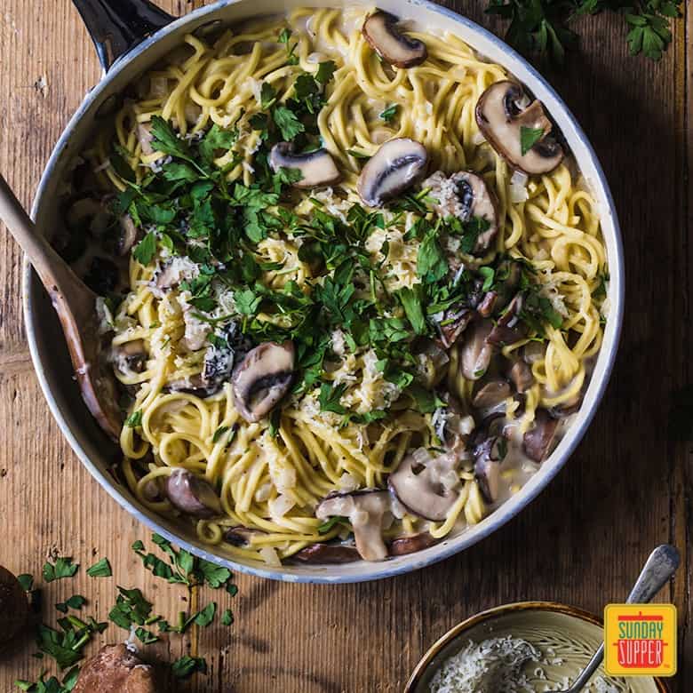 Creamy mushroom pasta in a skillet with a fork