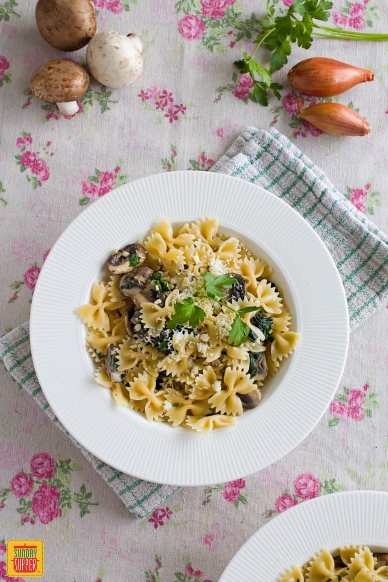 Mushroom Spinach Pasta served on a white plate with fresh parsley
