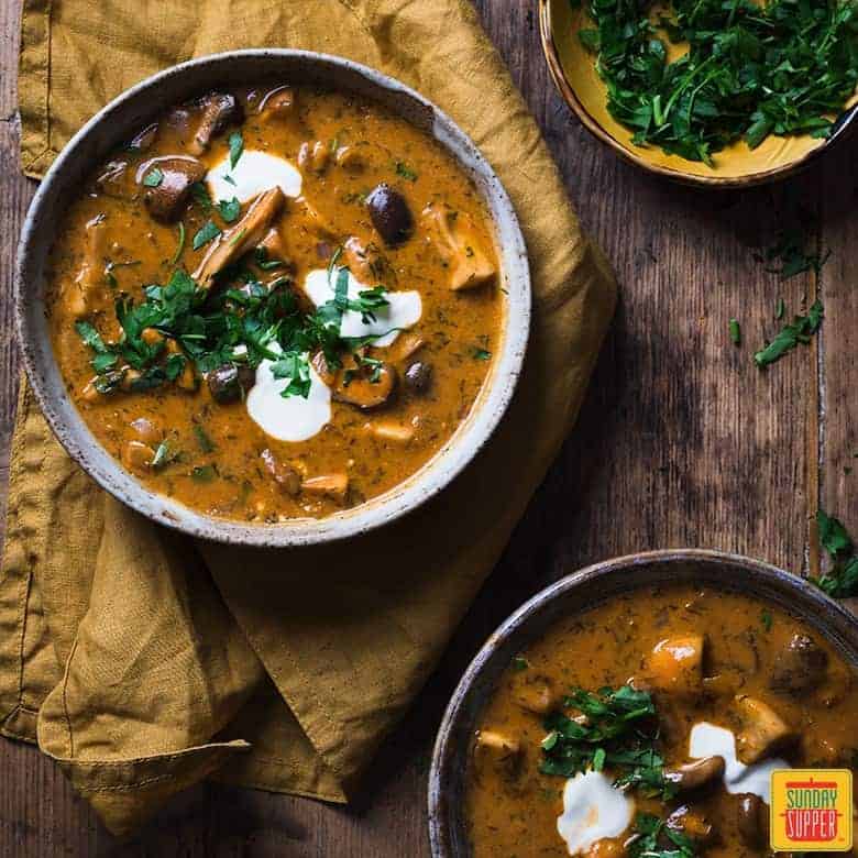 hungarian mushroom soup served with fresh chopped parsley and sour cream in bowls