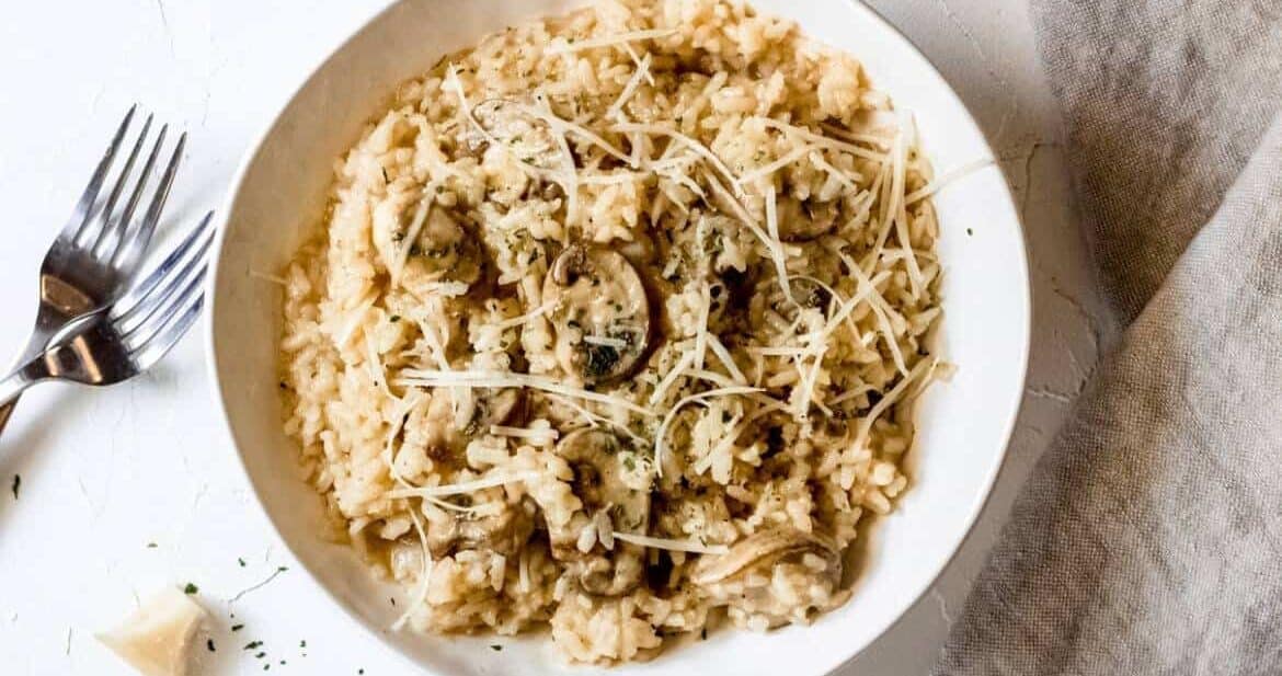 Mushroom risotto recipe served in a white bowl with a fork