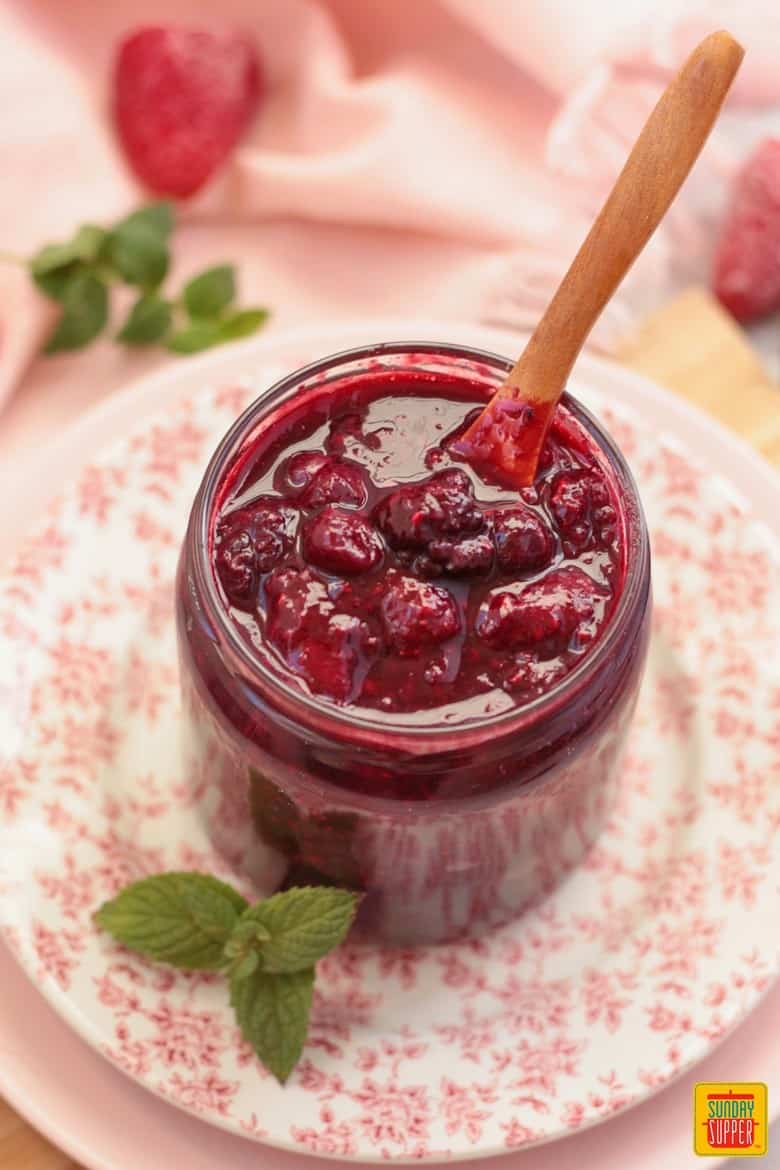 Freshly made Berry Compote from above with mint on a floral plate