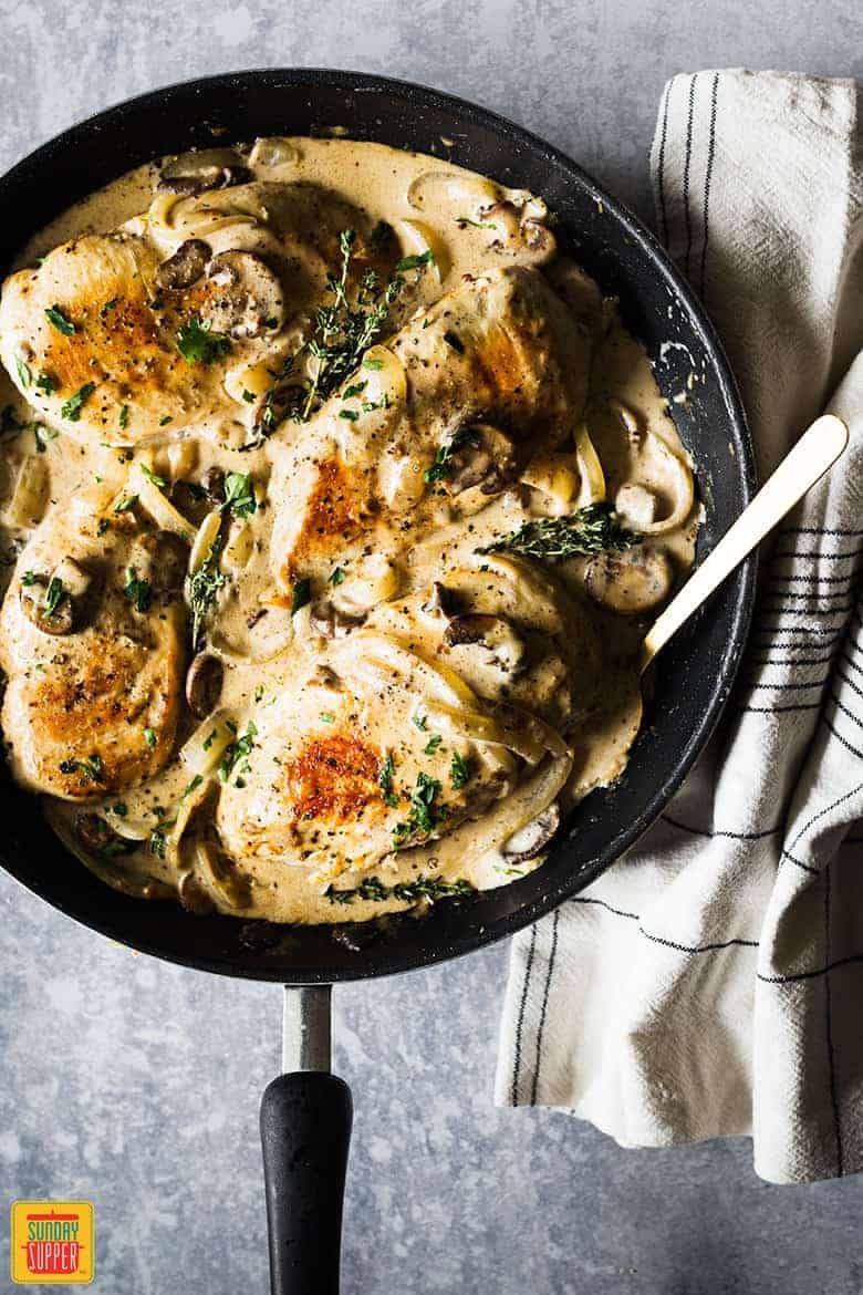 chicken breast and mushroom recipe in pan with spoon to serve