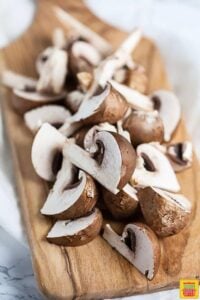 Baby Bella portobello mushrooms on a cutting board, cleaned and ready to use for air fryer mushrooms