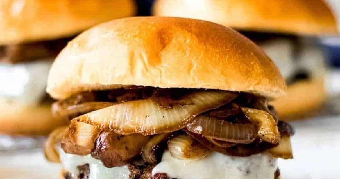 Close up of mushroom swiss burger in front of two other burgers