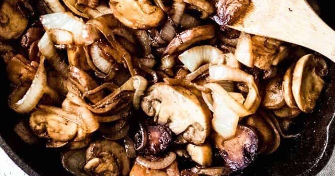 Sauteed onions and mushrooms in a cast iron skillet caramelized and ready to eat