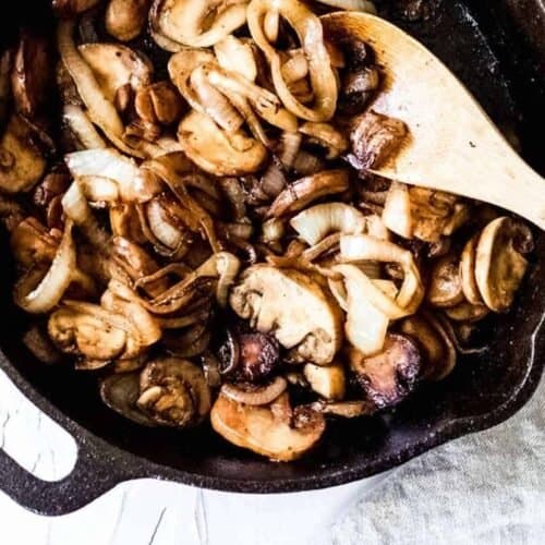 Sauteed onions and mushrooms in a cast iron skillet caramelized and ready to eat