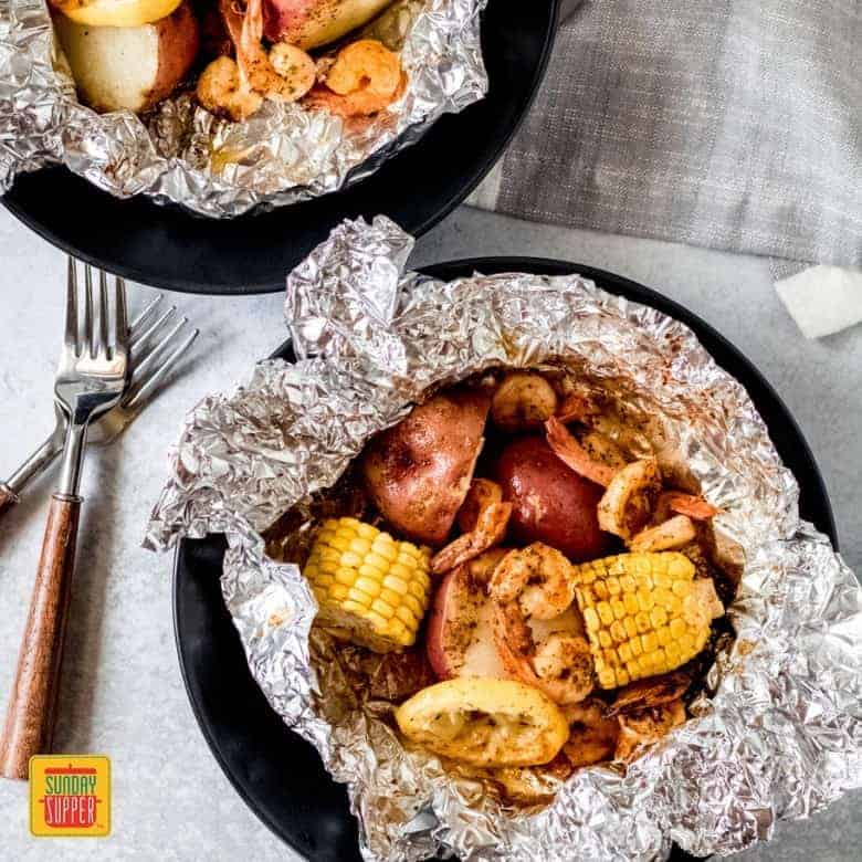 two shrimp foil packs in foil on a table