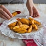 eating baked crispy potato wedges