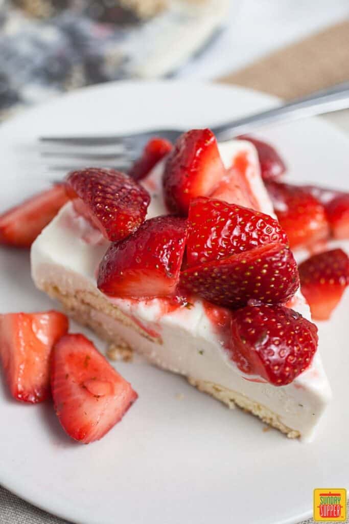 Slice of Carlota de Limon topped with fresh strawberries