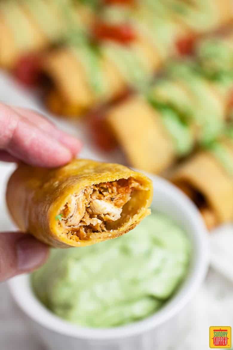 Chicken Taquitos Recipe: chicken taquito with a bite taken out of it