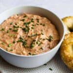 Beer cheese dip (obatzda) served in a white bowl with fresh chives and soft pretzels