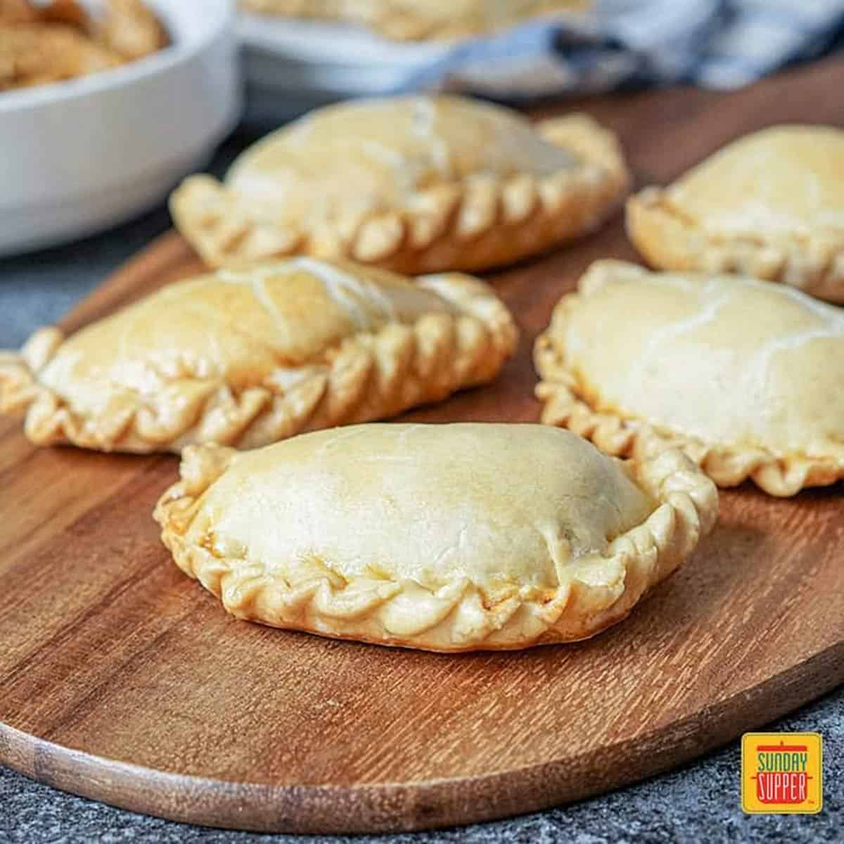 Close up of chicken empanadas on a wooden board