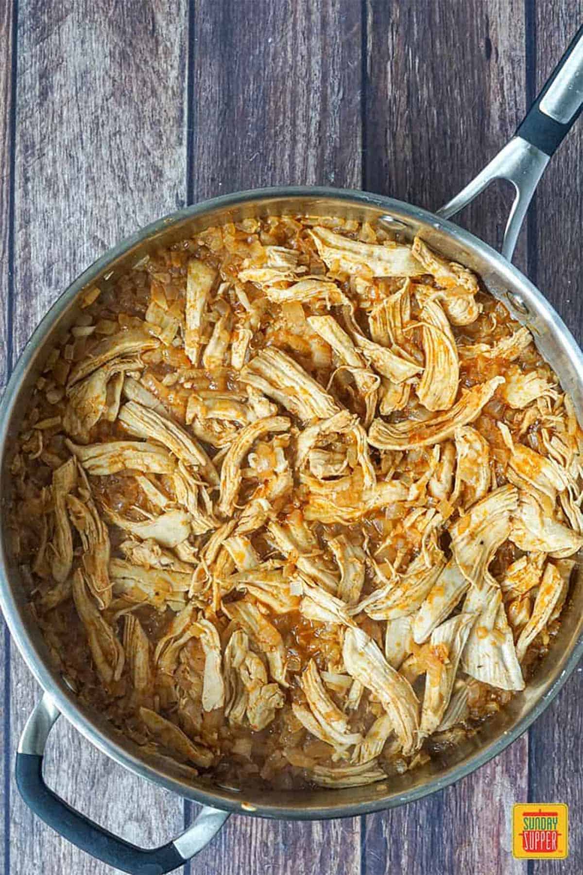 Shredded chicken and empanada filling in a skillet