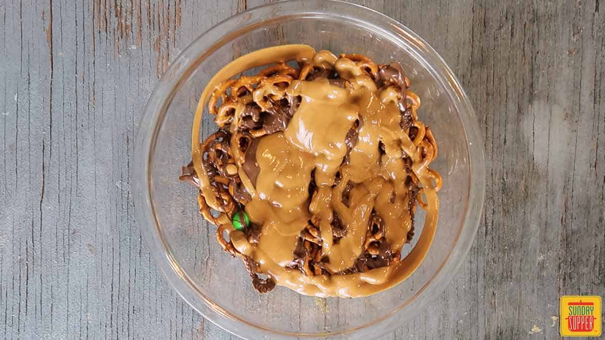 Peanut butter and chocolate poured over pretzel mix