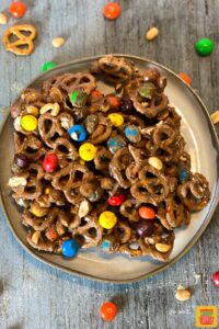 Overhead shot of a plate full of chocolate peanut butter snack mix with pretzels
