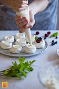 Piping the mini pavlovas filling in the