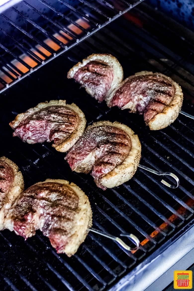 Picanha steak skewers cooking on the grill