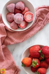 frozen strawberries and fresh strawberries in separate bowls