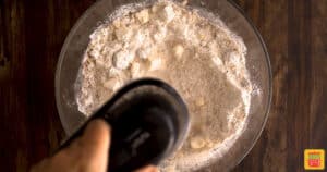 Mixing the oats and flour with an electric mixer in a glass bowl