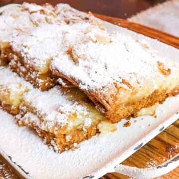 squares of ooey gooey butter cake on a rustic white serving platter