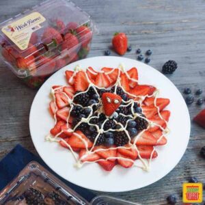 spider-man web berry dessert on white plate with container of wish farms strawberries