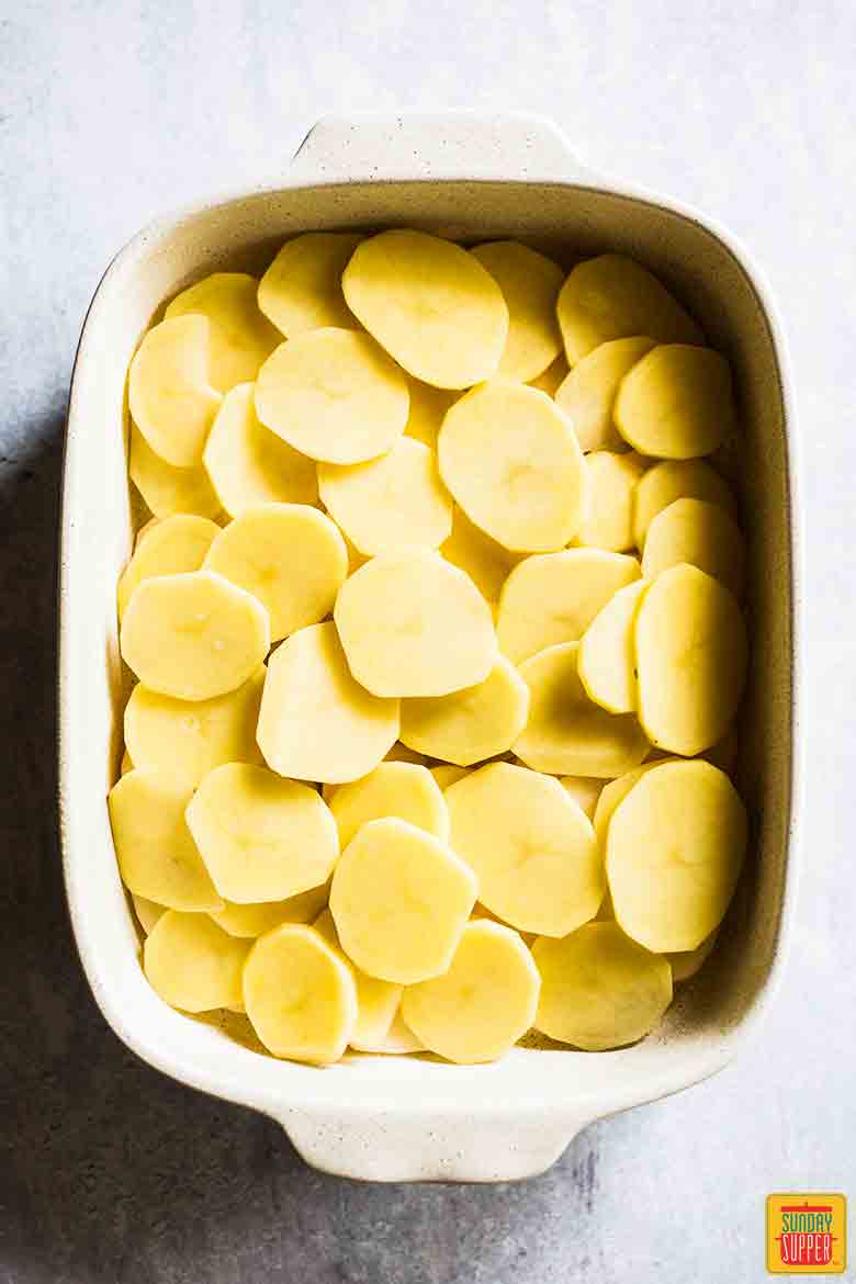 Potatoes layered in dish for Easy Scalloped Potatoes Recipe