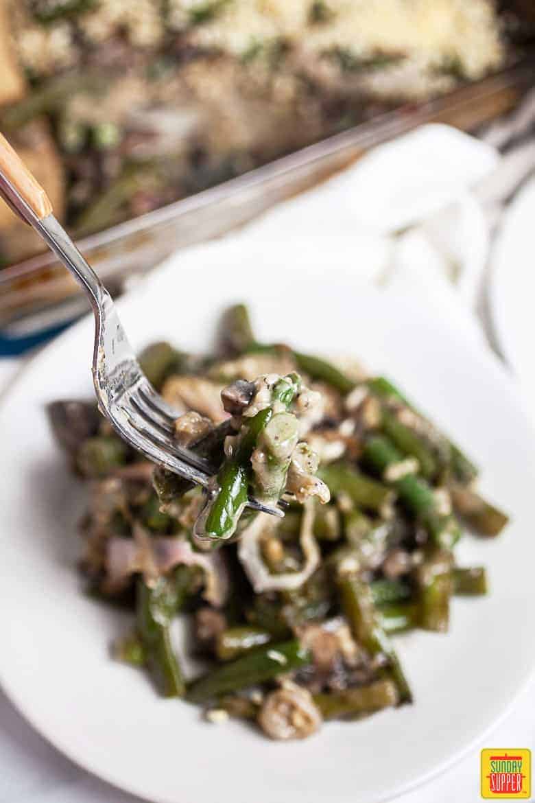 Gluten Free Green Bean Casserole with forkful of casserole over a white plate