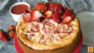 Strawberry swirl cheesecake with fresh berries on top