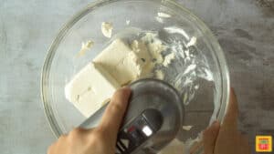 Beating cream cheese until smooth