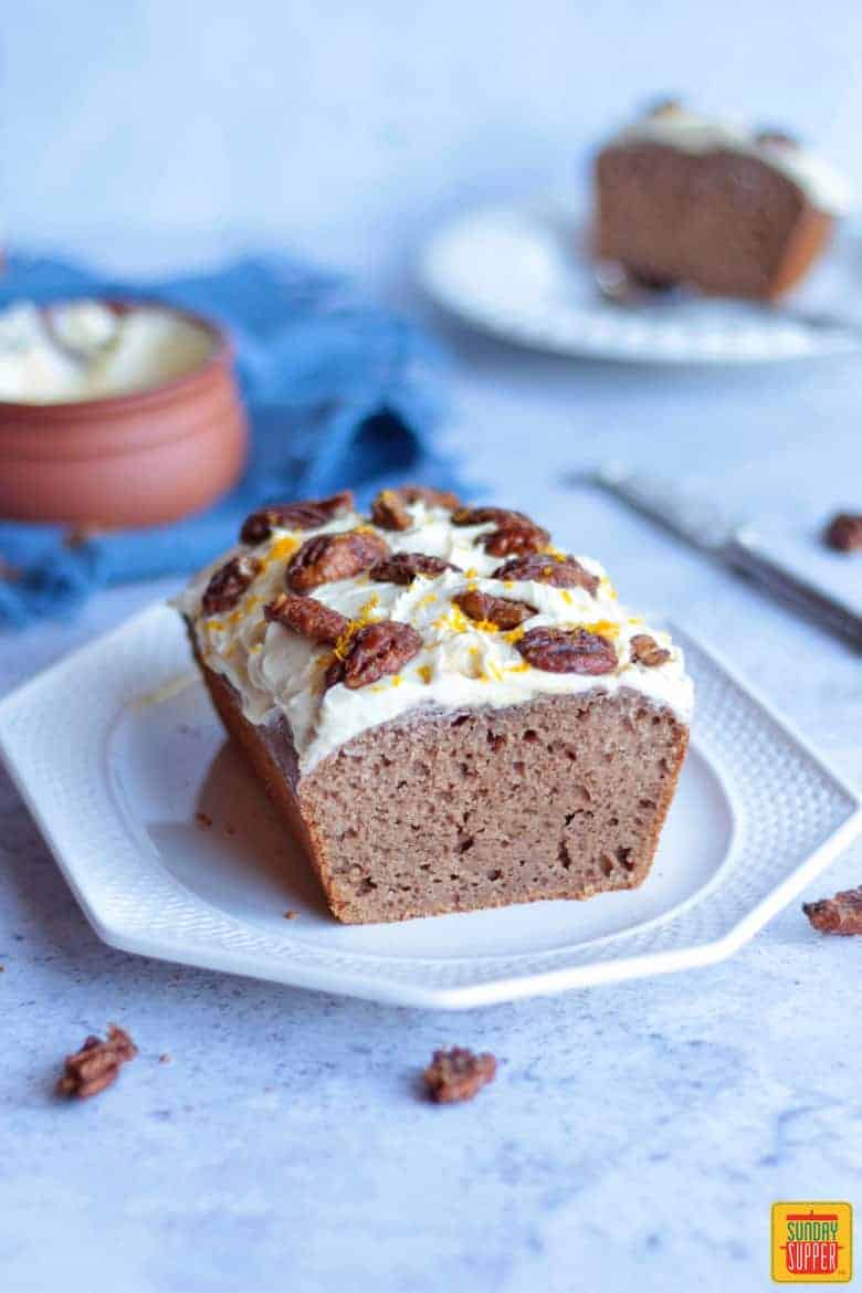 Gingerbread Loaf on a white platter with candied pecans on top