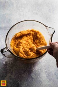 Mixing ingredients into sweet potatoes for Southern sweet potato casserole