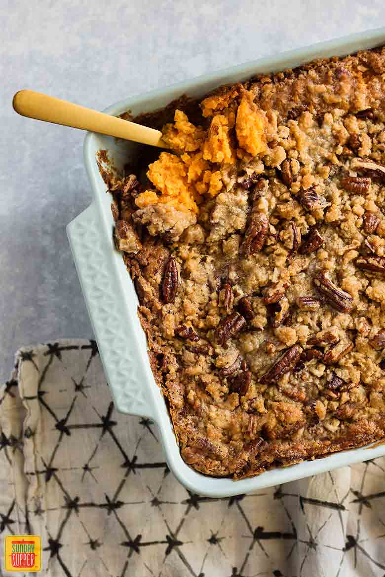 Southern sweet potato casserole in a baking dish with a serving spoon