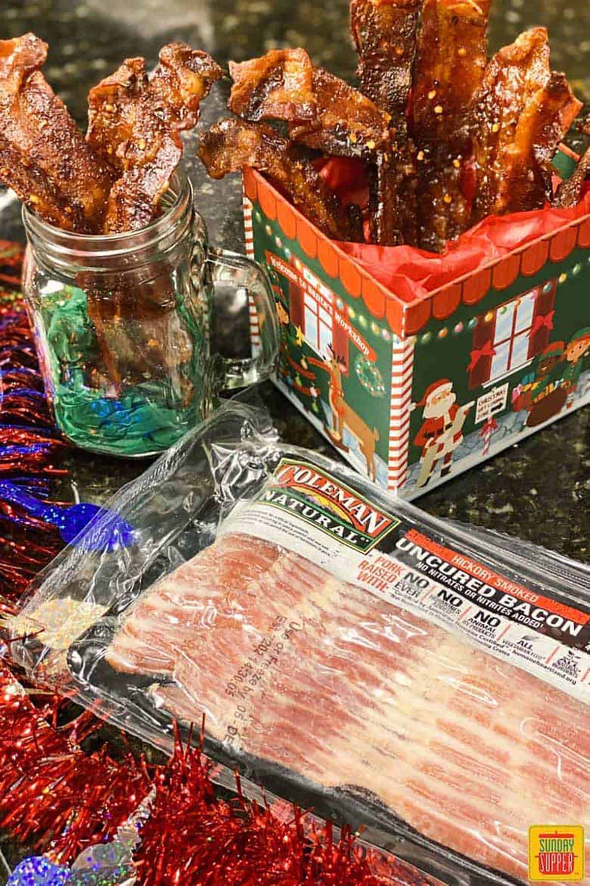 package of bacon with completed candied bacon in a jar and Christmas box