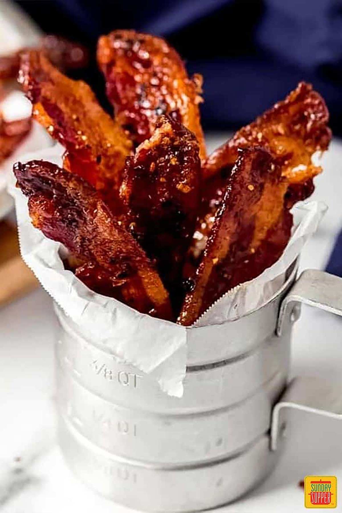Candied bacon in a metal cup