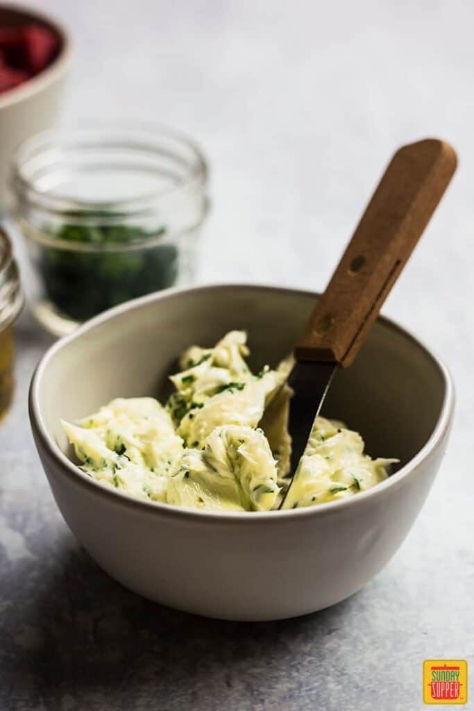 Garlic Butter in a white bowl with a serving butter knife