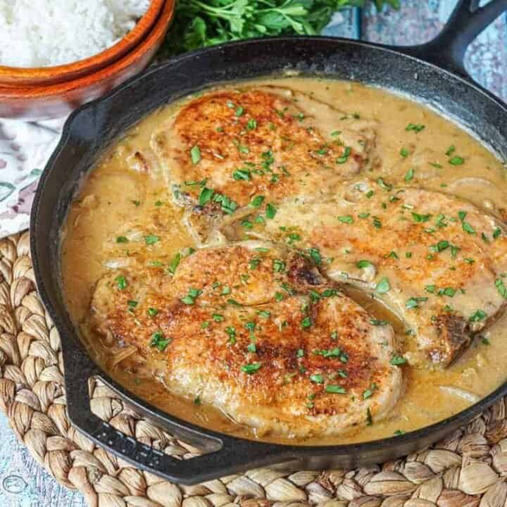 Southern smothered pork chops in a cast iron skillet