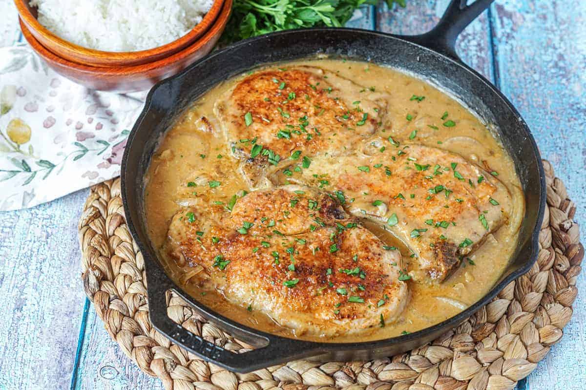 Southern smothered pork chops in a cast iron skillet