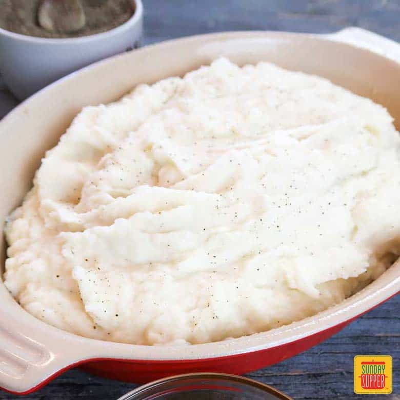 creamy mashed potatoes in a red casserole dish