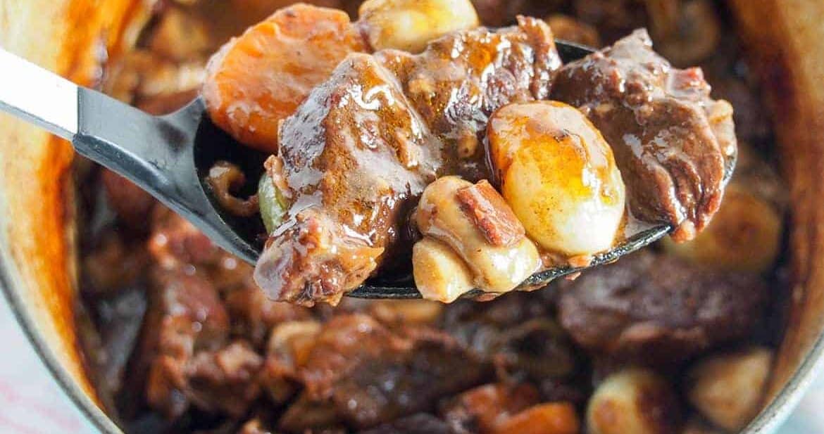 easy beef bourguignon recipe with spoonful held over pot