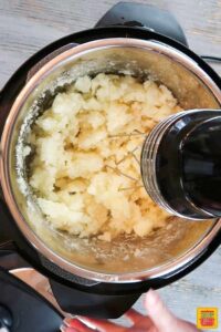 Using an electric hand mixer to mix the potatoes