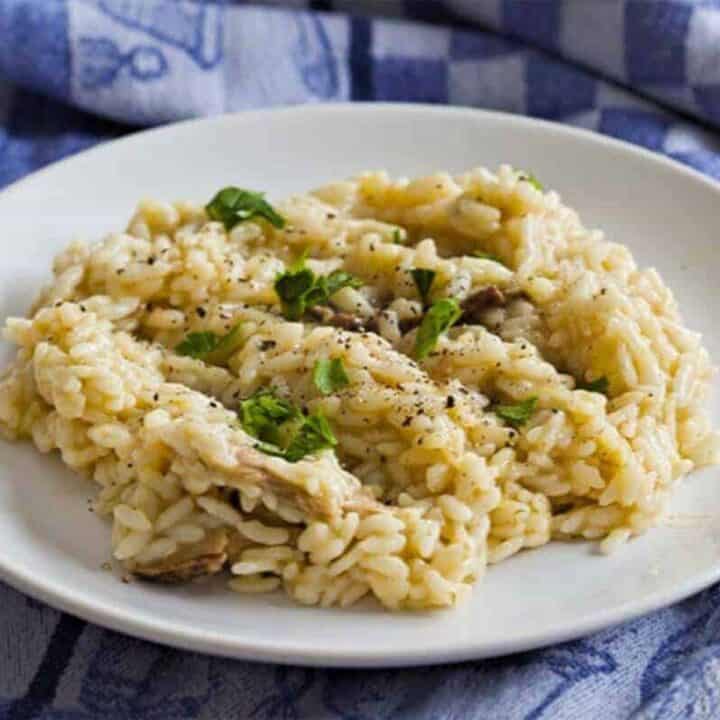 Instant Pot Risotto with porcini mushrooms served on a plate with a blue napkin