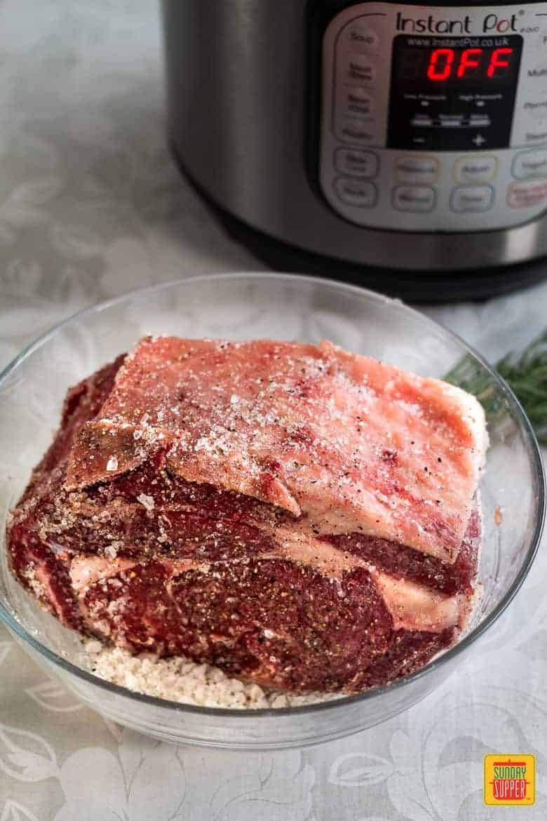 raw rib roast on a plate by the instant pot
