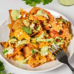 chilaquiles on a white plate with a fork