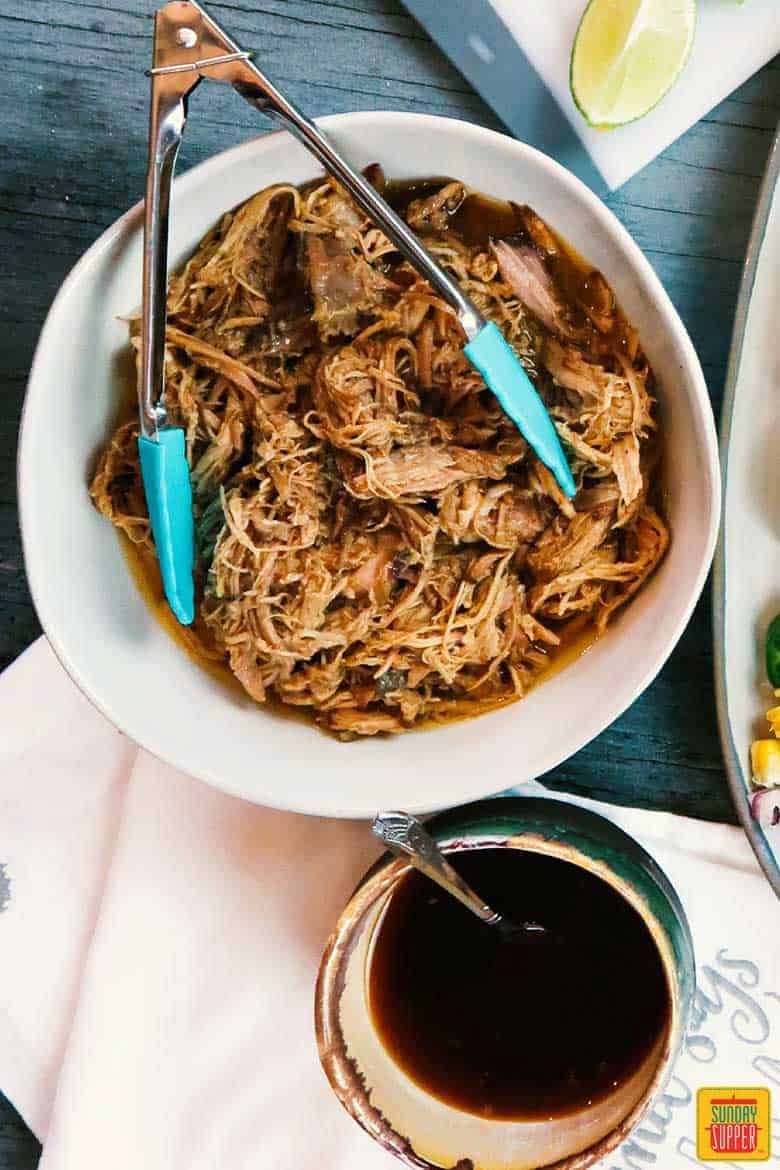 How to make pulled pork: Extra teriyaki sauce and shredded pork in a bowl with tongs